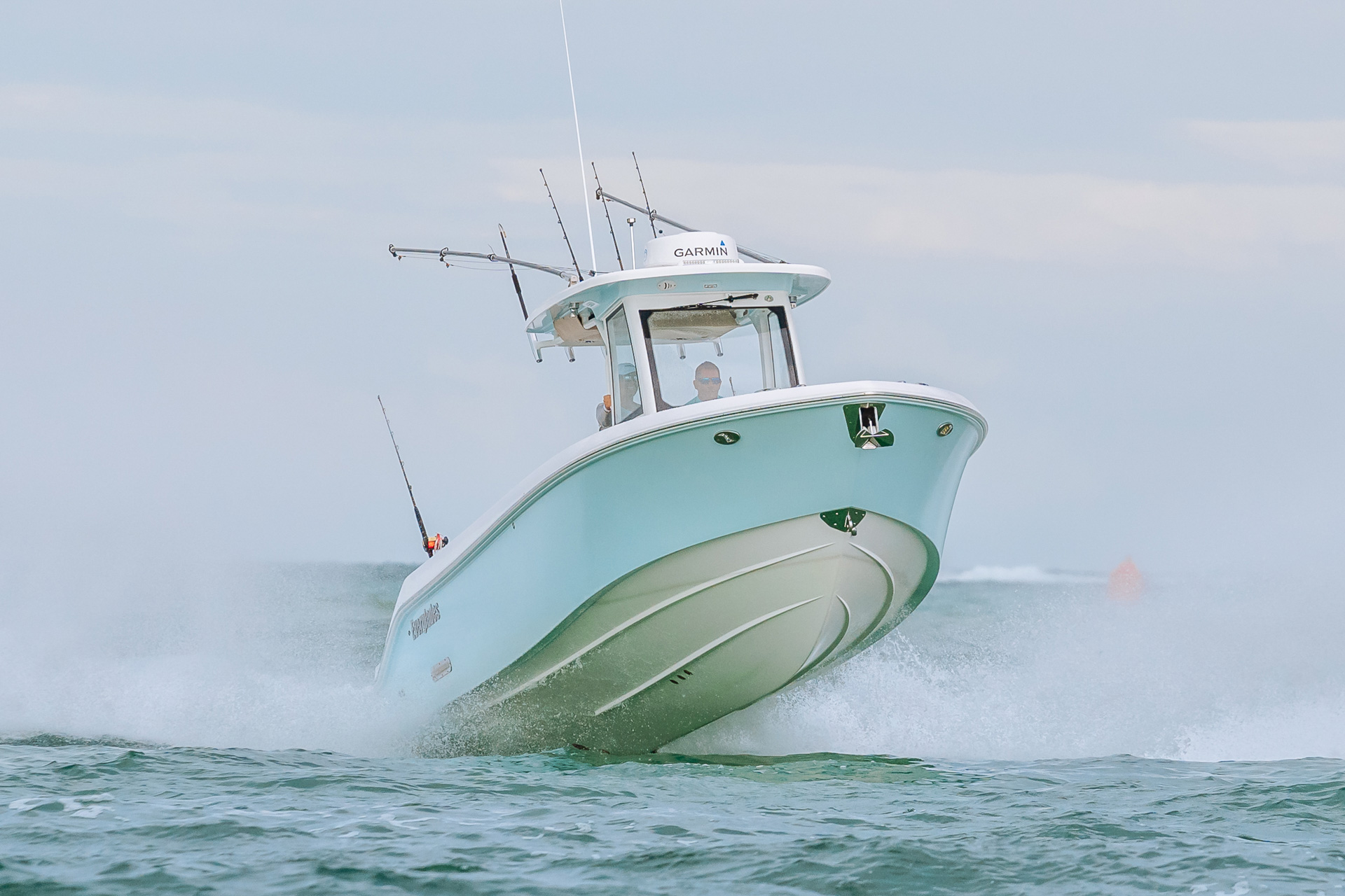 An Everglades boat on the water with fishing rods and spraying water at the stern