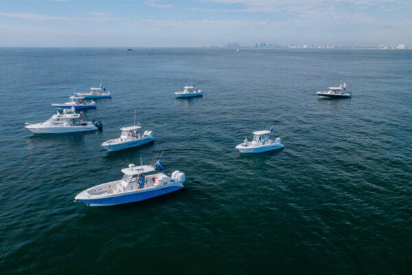 Group of everglade fishing boats in the water off the coast of a city