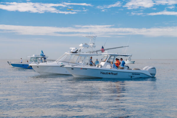 Two Everglades boats are stationary on a calm sea under a clear blue sky
