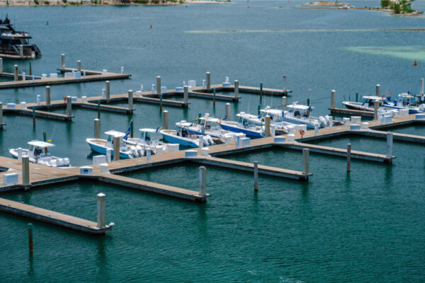 Aerial view of a marina with multiple Everglades boats docked at the piers in calm water