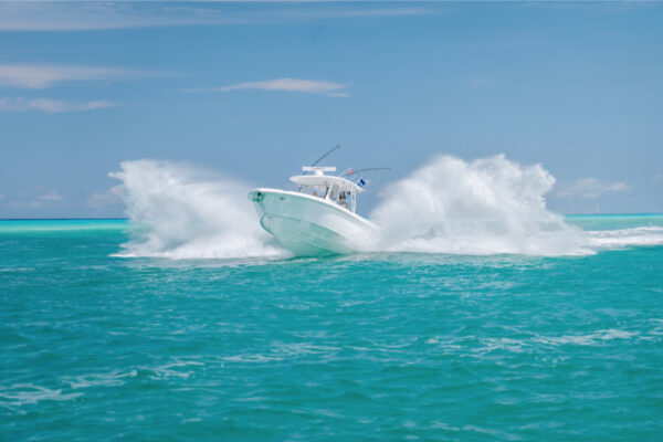 An Everglades boat creating a large splash with a clear sky in the background