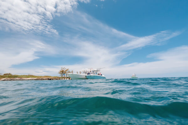 Low angle view of three Everglades boats under a blue sky with clouds, seen from water level