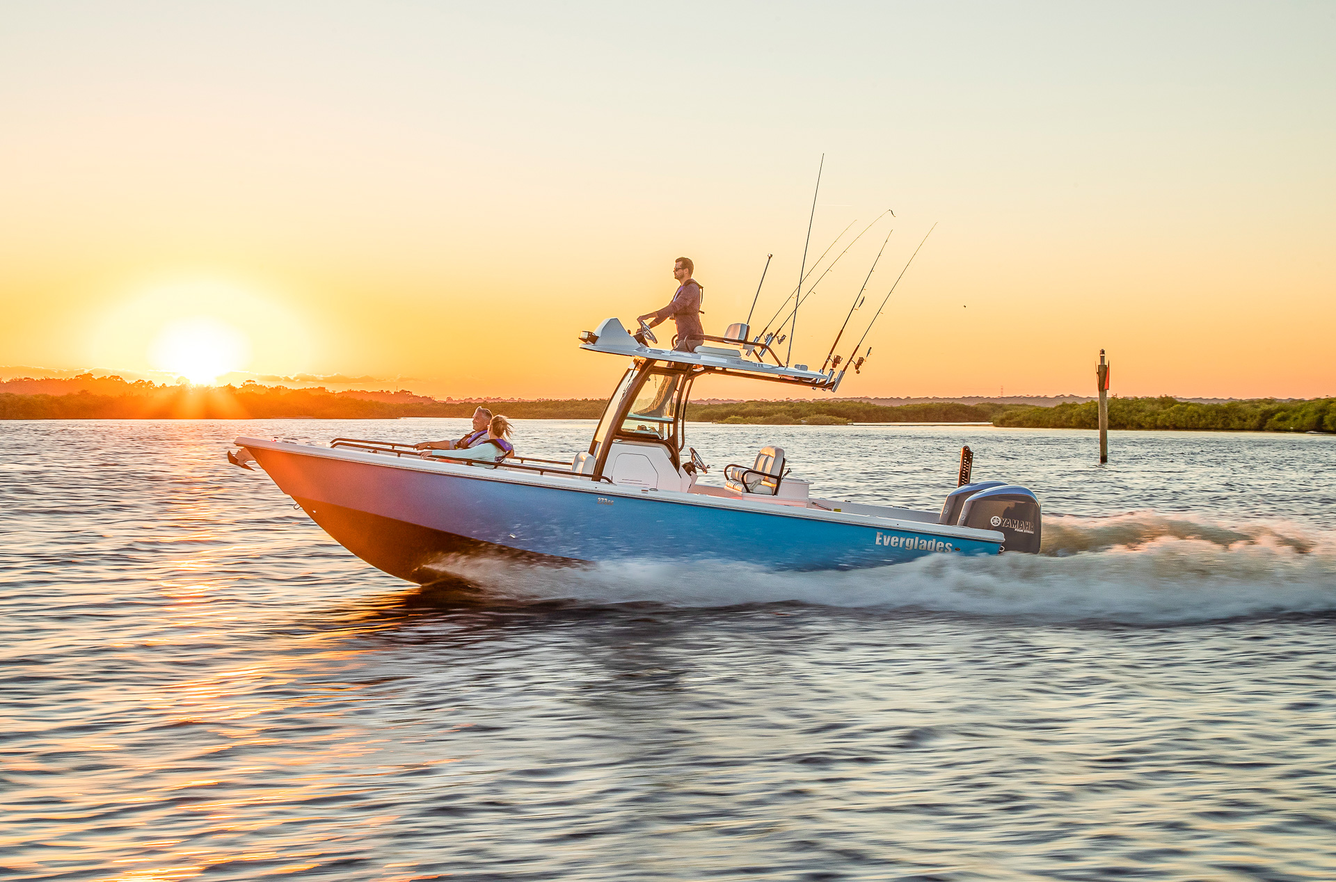 Man driving everglades boat at sunset